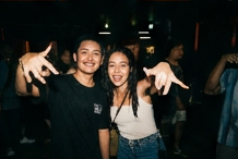 Two friends throwing shakas at a show